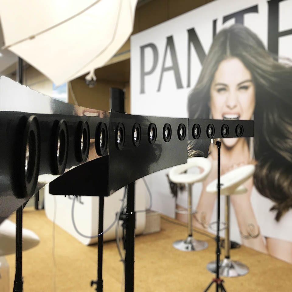 Bullet Time Photobooth rig. Behind it Pantene poster with brown - haired lady.
